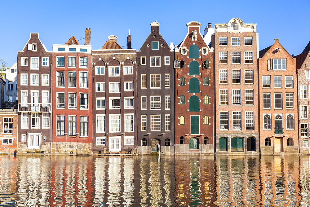 tall buildings along a canal that are different natural colors